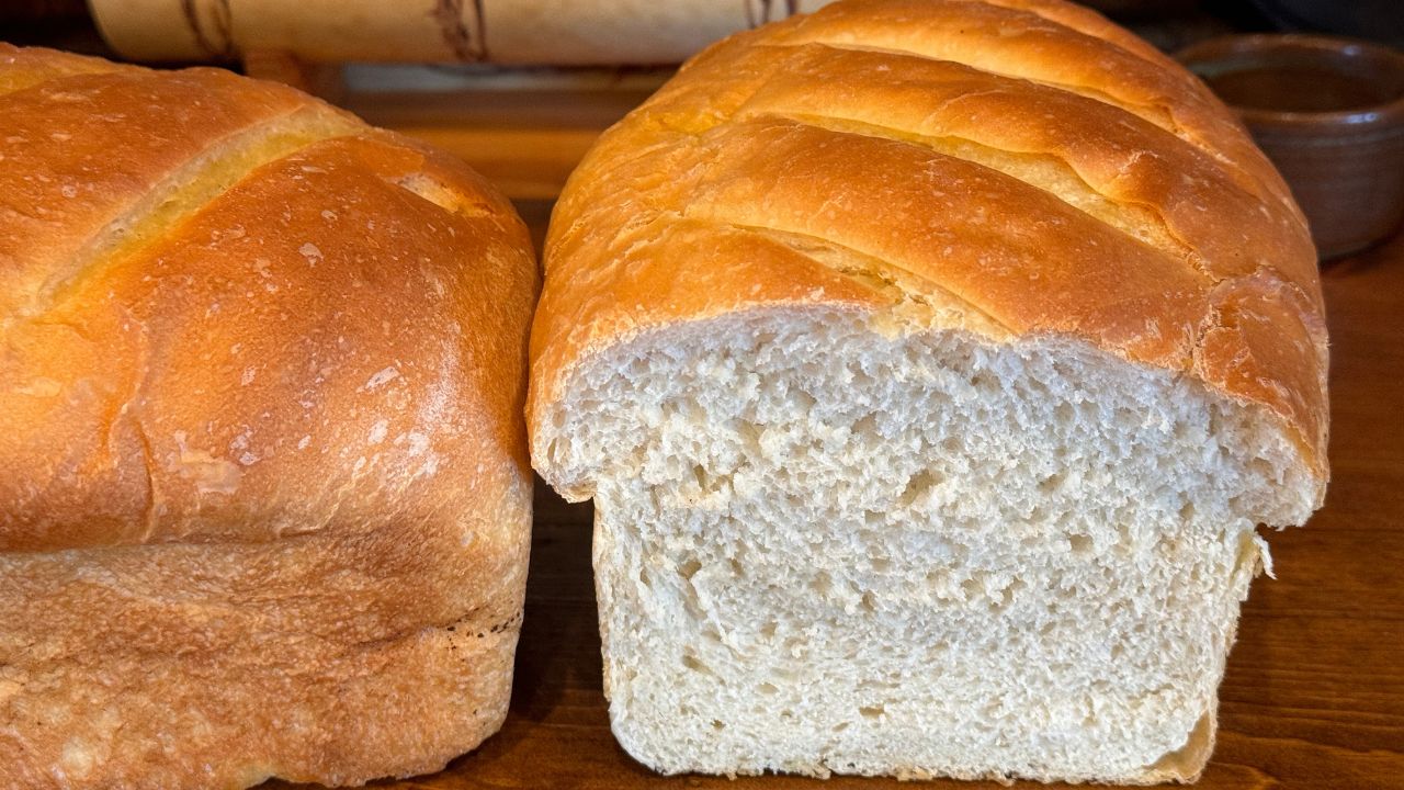 fresh out of the oven loaf of sourdough sandwich bread cut in half.