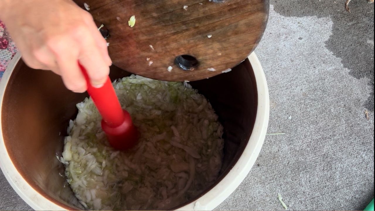 working homemade sauerkraut with a mallet