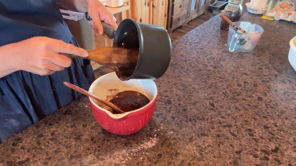 adding melted chocolate to brownie batter