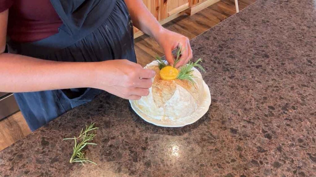 garnishing butter candle with fresh rosemary