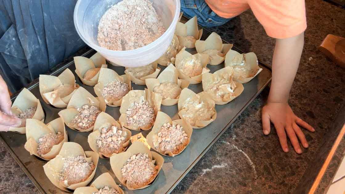 adding crumble topping to pumpkin muffins