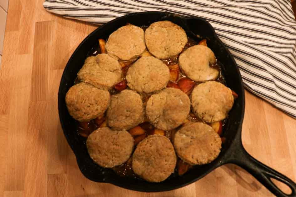 fresh baked sourdough peach cobbler in cast iron skillet
