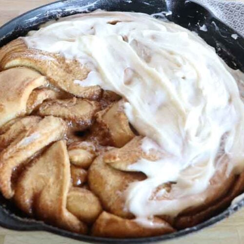 sourdough cinnamon twist with frosting in skillet up close