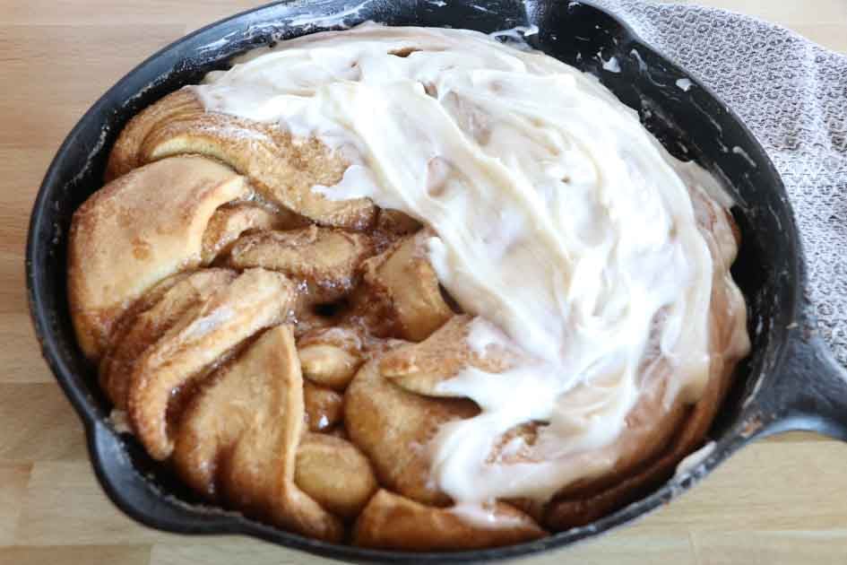 sourdough cinnamon twist with frosting in skillet up close