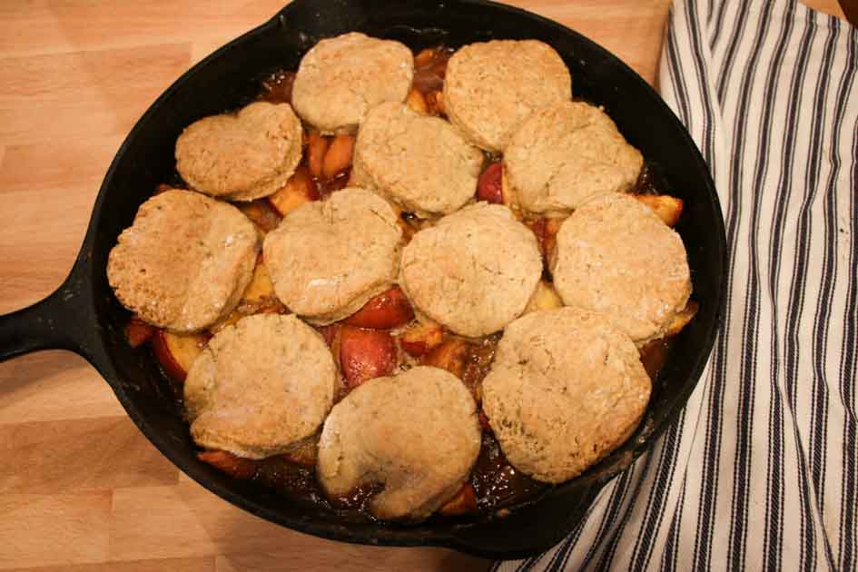 sourdough peach cobbler in cast iron skillet