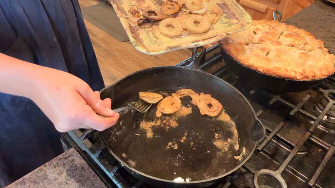 taking sourdough onion rings out of the skillet