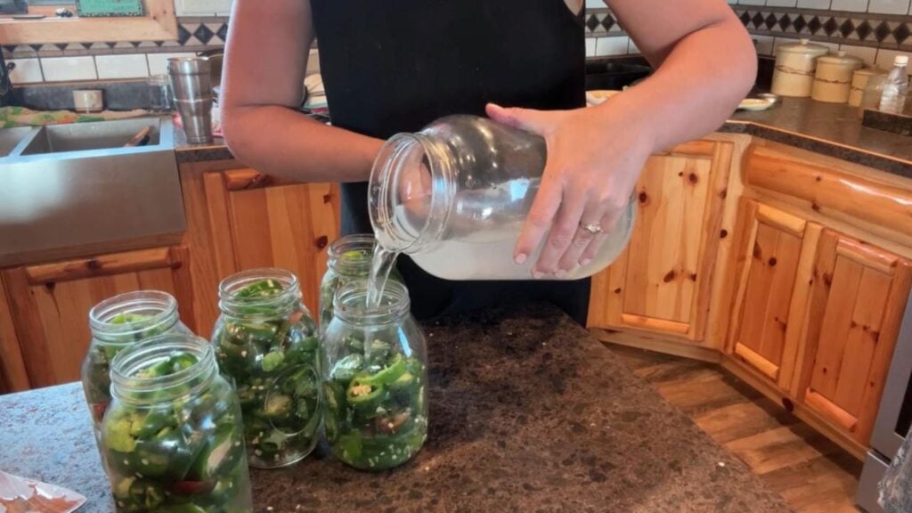 adding salt brine to slice jalapenos