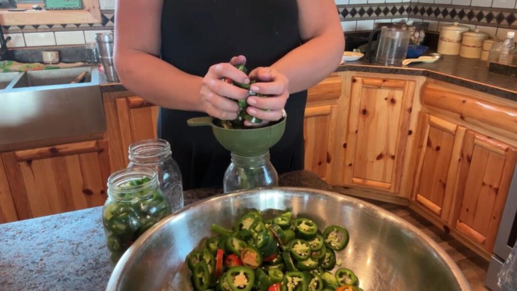 adding sliced jalapenos to jar