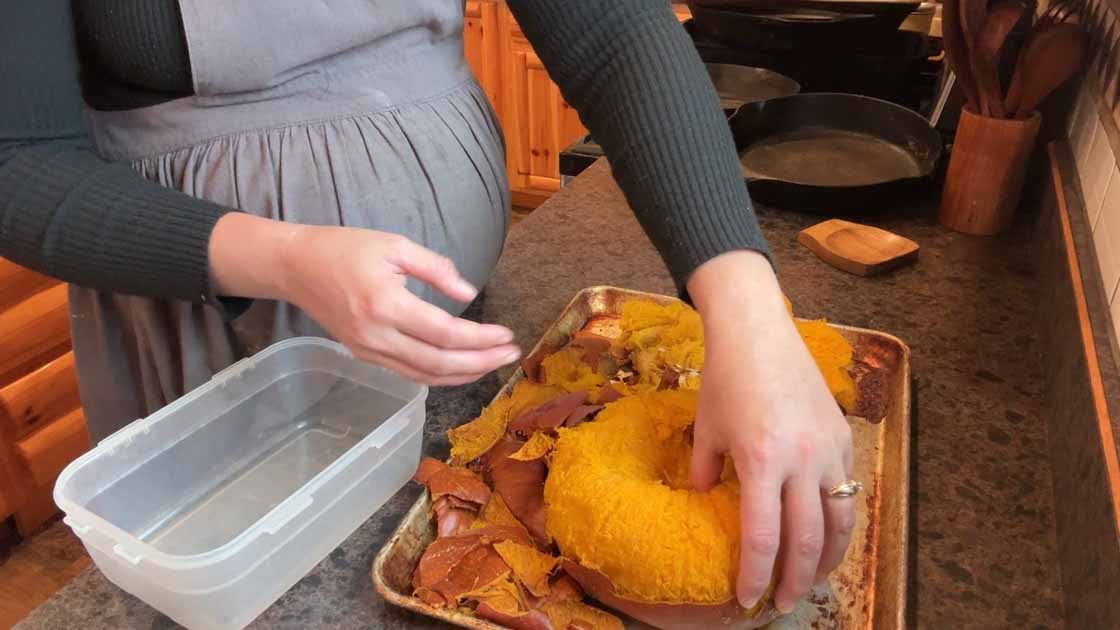 peeling a baked pumpkin for puree