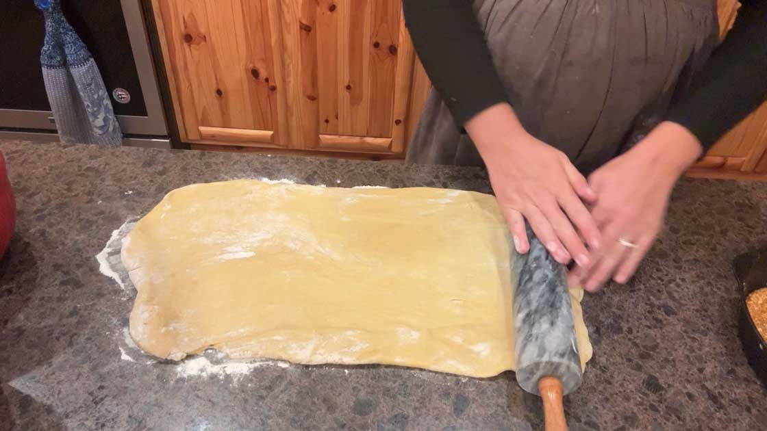 rolling out pumpkin cinnamon rolls