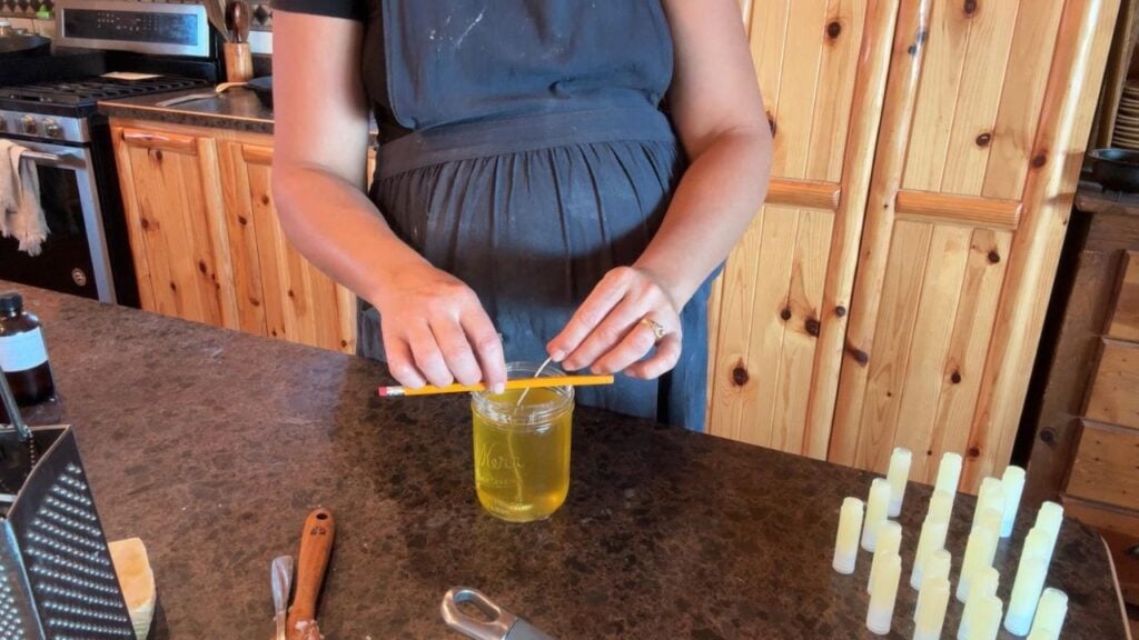 using a pencil to stabilize the candle wick