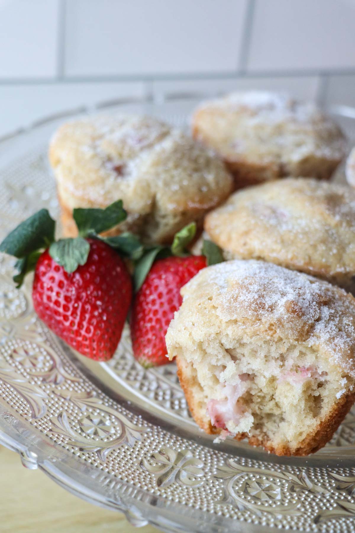 bite of sourdough strawberry muffins on platter vertical