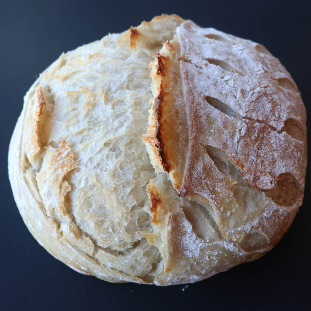 loaf of artisan sourdough bread on black square