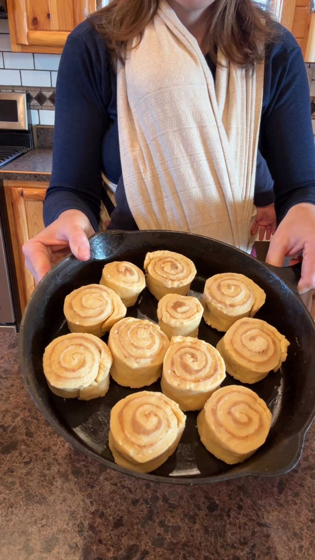 pan full of orange cinnamon rolls ready to raise.