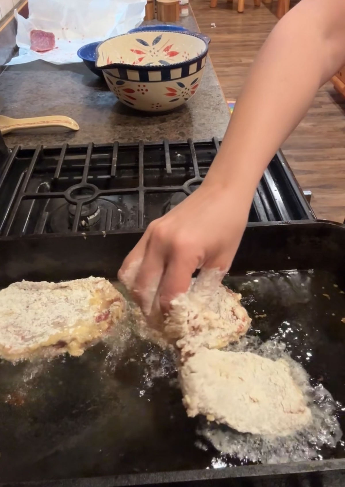 adding chicken fried steaks to hot oil