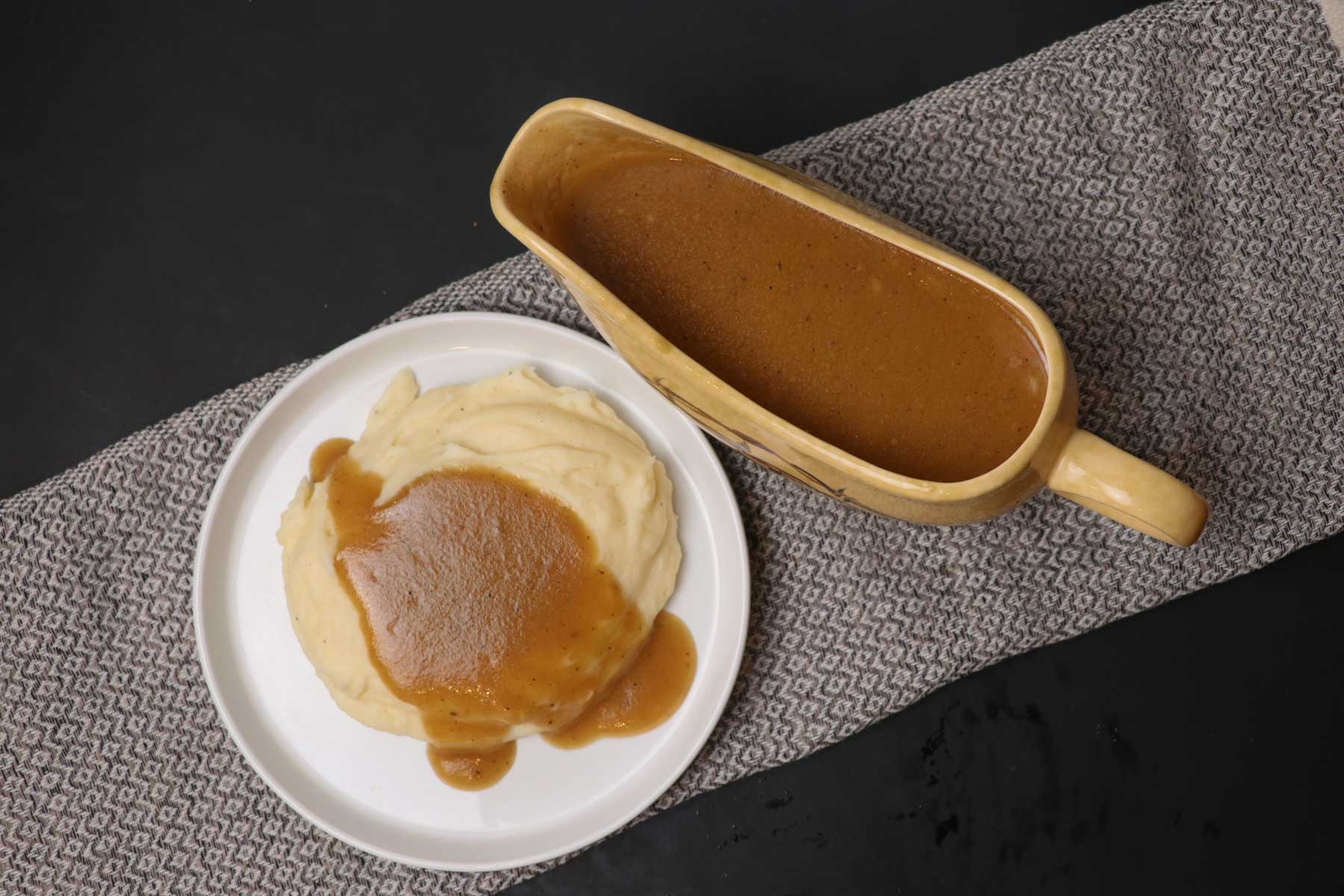 brown gravy in gravy boat on black