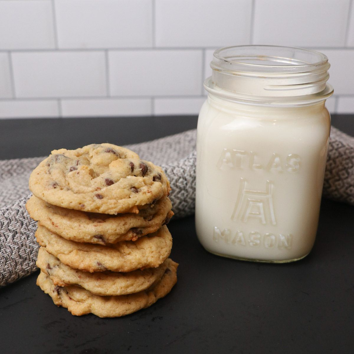 stack of chocolate chip cookies with milk square