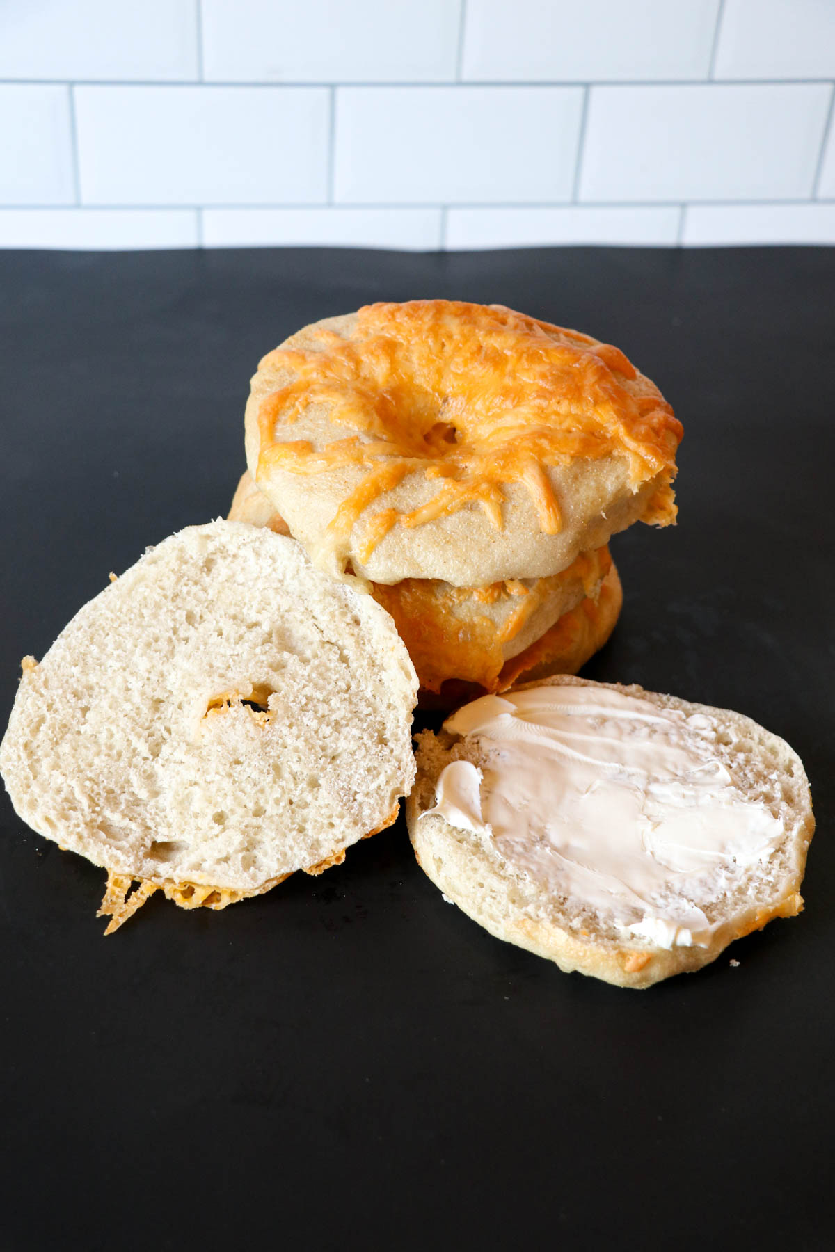 stack of garlic cheese bagels cut in half with cream cheese