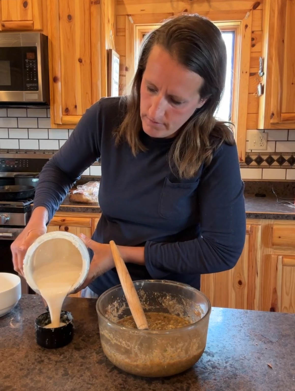 adding wet ingredients to bowl for sourdough zucchini bread