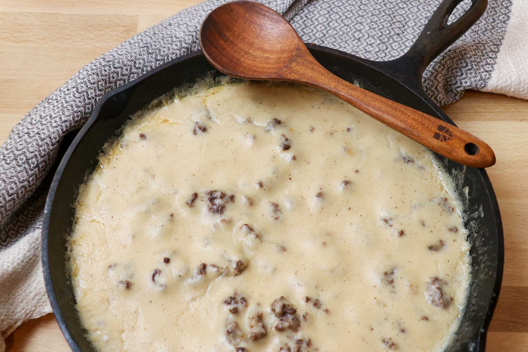 sausage gravy in skillet with ladle