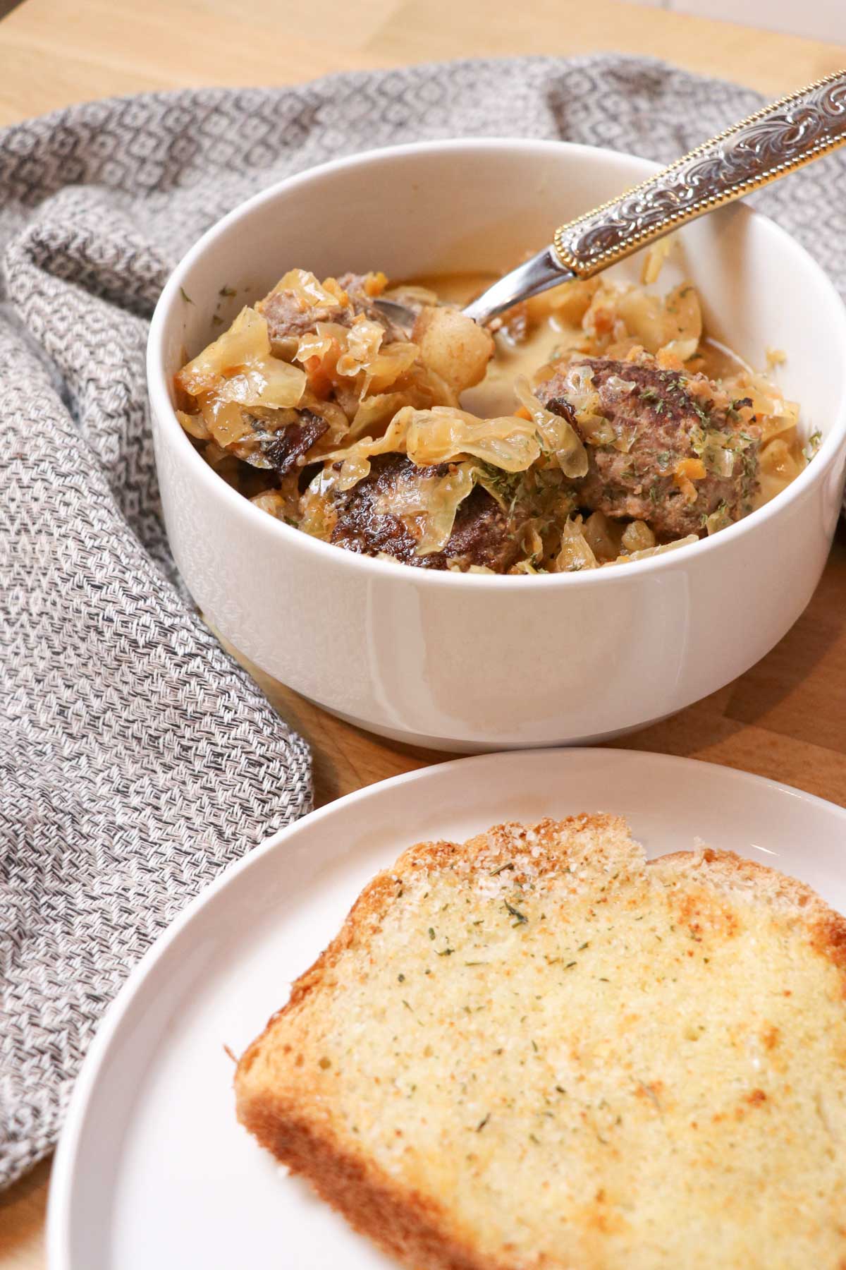 bowl of sauerkraut sausage soup with garlic bread